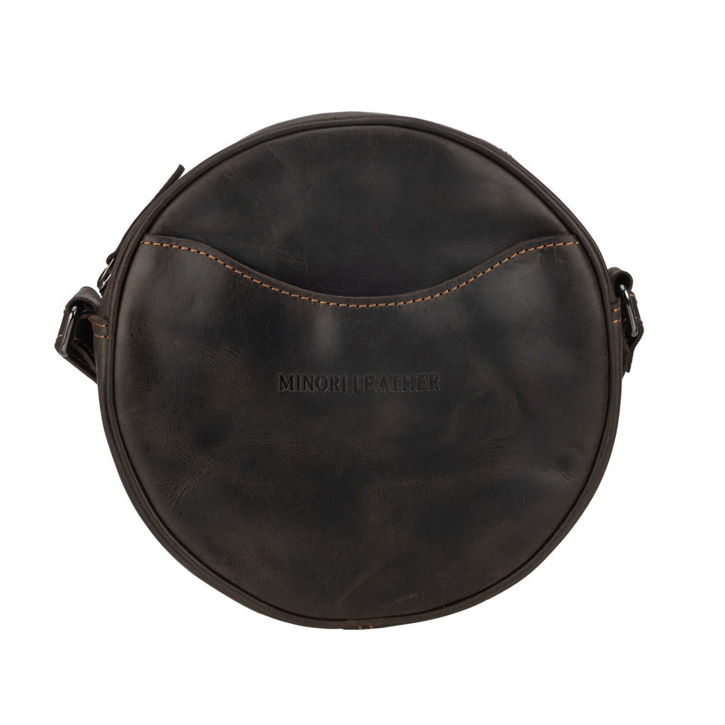Minori Leather Luna leather round crossbody bag in chestnut, brown, and hair-on brown with adjustable strap and textured finish.